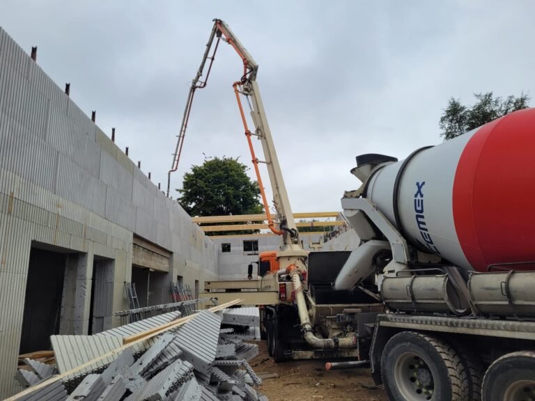 Camion-pompe coulant le béton dans des murs en bloc coffrant isolant