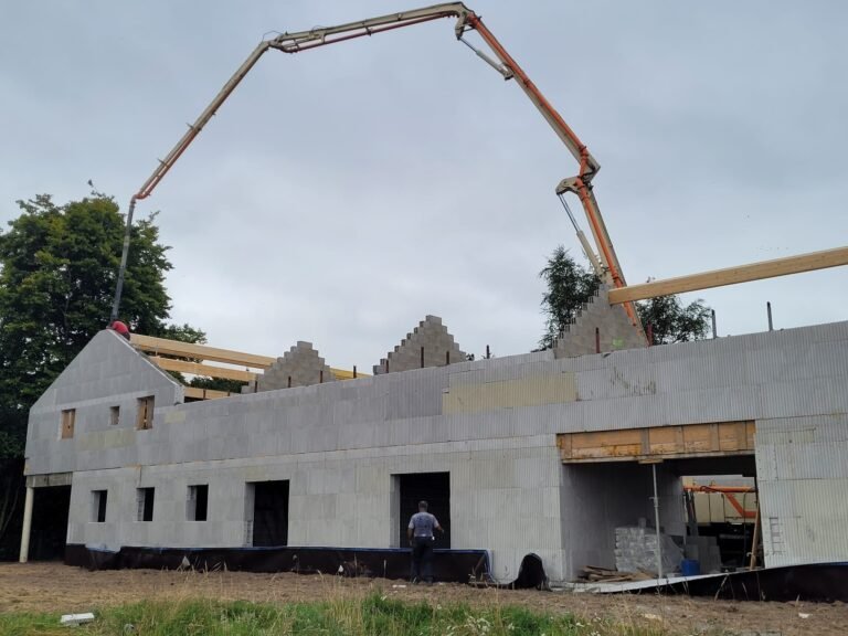 Murs et pignons en bloc coffrant isolant pendant le coulage à la pompe, chantier Toki France