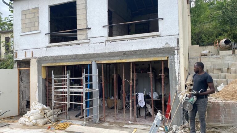 Façade de maison ouverte au rez-de-chaussée, maintenue par des étais