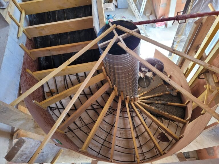 Coffrage bois et ferraillage d'un escalier hélicoïdal en béton, vu du dessus